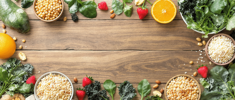 Aliments riches en fibres avec fruits rouges, légumes verts, céréales et légumineuses sur une table en bois