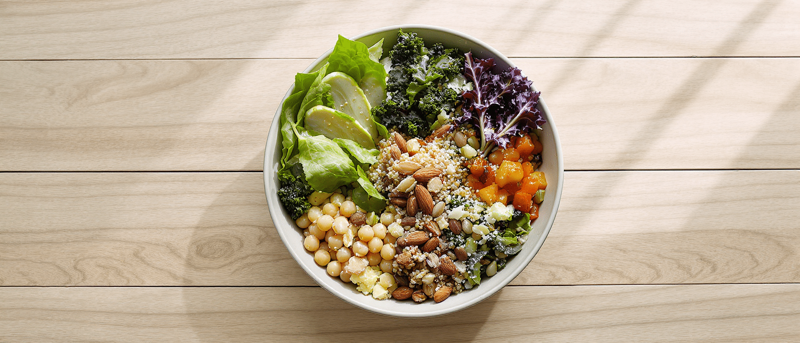 salade-magnesium-legumineuses Bol de salade colorée composé de pois chiches, légumes verts, graines, noix et amandes, riche en magnésium et nutriments essentiels.